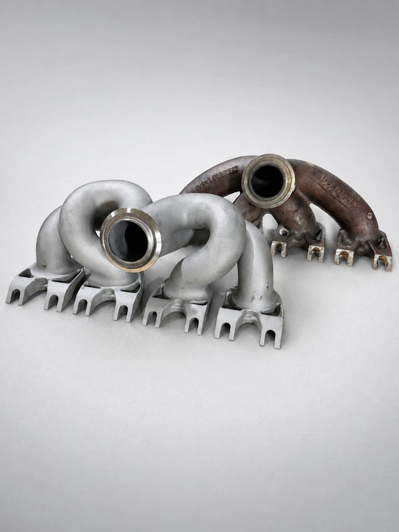 Three-quarter view of ModalWorks M177 exhaust manifold beside the OEM manifold